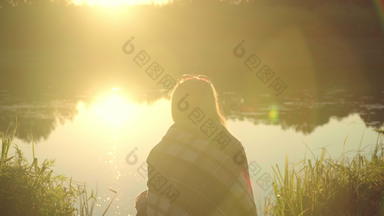 孤独的女孩格子坐着河银行射线离开太阳孤独的女人